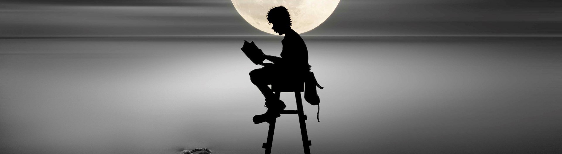 坐在月光下讀書的小男孩